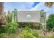 A close-up of the Honeymoon Island sign amidst lush greenery under a partly cloudy sky at 1926 Fairway W Cir, Dunedin, FL 34698