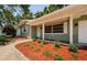 Inviting entrance featuring a covered porch with decorative accents and well-manicured landscaping at 1926 Fairway W Cir, Dunedin, FL 34698