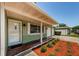 Inviting entrance featuring a covered porch with decorative accents and well-manicured landscaping at 1926 Fairway W Cir, Dunedin, FL 34698