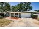 Charming single-story home featuring a well-maintained front yard and an attached garage at 1926 Fairway W Cir, Dunedin, FL 34698