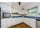 Bright kitchen featuring white cabinets, stainless steel appliances, and wood flooring at 1926 Fairway W Cir, Dunedin, FL 34698