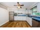 Charming kitchen with white cabinets, stainless steel appliances, and wood flooring at 1926 Fairway W Cir, Dunedin, FL 34698