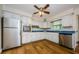 Charming kitchen with white cabinets, stainless steel appliances, and wood flooring at 1926 Fairway W Cir, Dunedin, FL 34698
