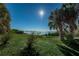 Lush Dunedin landscape with palm trees framing a serene water view, bathed in sunlight at 1926 Fairway W Cir, Dunedin, FL 34698