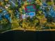 Aerial view of community amenities: tennis courts, swimming pool, and a dock on the tranquil lake at 204 Lake Charles Ct, Oldsmar, FL 34677