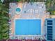 Aerial view of a pool area surrounded by lounge chairs and mature trees at 204 Lake Charles Ct, Oldsmar, FL 34677