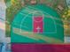Aerial shot of a green and red basketball court with an adjacent walkway and several trees at 204 Lake Charles Ct, Oldsmar, FL 34677