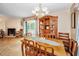 Elegant dining room with wood table and chairs, chandelier, hutch and sliding glass doors to the backyard at 204 Lake Charles Ct, Oldsmar, FL 34677