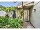 Close-up of a charming front entrance with well-maintained landscaping and a decorative storm door at 204 Lake Charles Ct, Oldsmar, FL 34677