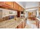 Modern kitchen with granite countertops, wood cabinets and views of the adjoining rooms at 204 Lake Charles Ct, Oldsmar, FL 34677