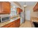 Charming kitchen featuring wood cabinets, tile floors, granite countertops, and ample natural light at 204 Lake Charles Ct, Oldsmar, FL 34677
