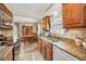 Eat-in kitchen features granite counters, wood cabinetry, and modern appliances at 204 Lake Charles Ct, Oldsmar, FL 34677