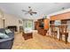 Cozy living room features a brick fireplace, a ceiling fan, and natural light from sliding glass doors at 204 Lake Charles Ct, Oldsmar, FL 34677