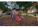 Community playground with multiple slides and climbing structure surrounded by trees at 204 Lake Charles Ct, Oldsmar, FL 34677