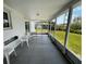 View of the home's screened porch, featuring a gray tile floor, access to the backyard, and an abundance of light at 2195 Academy Dr, Clearwater, FL 33764