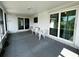 A gray tile floor is seen in this shot of the screened in porch, which features access to the home and the backyard at 2195 Academy Dr, Clearwater, FL 33764