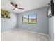 A bedroom with a ceiling fan, neutral walls, and a window view to the backyard at 2510 Laurelwood Dr # 5B, Clearwater, FL 33763