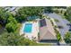 Aerial view of a pristine community pool with lounge chairs and a tennis court next to the clubhouse at 2510 Laurelwood Dr # 5B, Clearwater, FL 33763