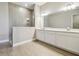 Elegant bathroom with double sinks, quartz countertops, and tiled shower at 2603 Wise River Ln, Zephyrhills, FL 33541