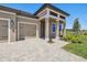 Inviting home facade showcasing a paver driveway, a two car garage, and a covered portico entry at 2603 Wise River Ln, Zephyrhills, FL 33541