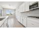 Modern kitchen showcasing sleek white cabinetry, stainless steel appliances, and a spacious island design at 2603 Wise River Ln, Zephyrhills, FL 33541