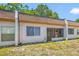 Back exterior showing the windows and a glass door with overgrown grass at 2928 Feather Dr, Clearwater, FL 33759