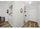 Hallway features wood-look flooring and entry to front door and kitchen at 2928 Feather Dr, Clearwater, FL 33759