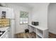 Bright corner of the kitchen features laminate flooring, a window and microwave on shelving at 2928 Feather Dr, Clearwater, FL 33759