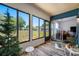 Bright sunroom featuring wood-look floors, expansive windows, and sliding door access to the home's interior at 2928 Feather Dr, Clearwater, FL 33759