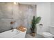 Modern bathroom featuring soaking tub, stone accent wall, and white toilet and vanity at 3202 Cullendale Dr, Tampa, FL 33618