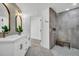 Modern bathroom featuring double sinks, stone wall shower, and gray tile flooring at 3202 Cullendale Dr, Tampa, FL 33618