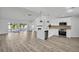 Open-concept kitchen with modern appliances, white cabinetry, and luxury vinyl plank flooring at 3202 Cullendale Dr, Tampa, FL 33618