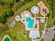 Aerial view of community pool and recreation area featuring multiple pools, splashpad, playground, and lounge seating at 33716 Elm Hill Br, Wesley Chapel, FL 33545