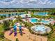 Aerial view of the community amenities including the pool, splash pad, playground, lake, and recreation center at 33716 Elm Hill Br, Wesley Chapel, FL 33545