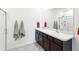 Bright bathroom featuring double sinks, a large mirror, and a glass-enclosed shower with tiled floors at 33716 Elm Hill Br, Wesley Chapel, FL 33545