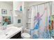 Bright bathroom with a combination shower and tub featuring a fun mermaid shower curtain at 33716 Elm Hill Br, Wesley Chapel, FL 33545