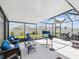 Screened in patio featuring ample seating, a tv, and outdoor cooking area with grill, and a view of the yard at 33716 Elm Hill Br, Wesley Chapel, FL 33545