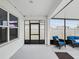 Covered patio featuring neutral concrete floors, black framed windows and furniture with eye-catching blue cushions at 33716 Elm Hill Br, Wesley Chapel, FL 33545