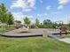 Community playground featuring a merry-go-round, swings, and play structures on a landscaped area at 33716 Elm Hill Br, Wesley Chapel, FL 33545