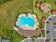 Aerial view of a resort-style community pool and amenity center with lush landscaping and a playground at 33716 Elm Hill Br, Wesley Chapel, FL 33545