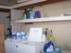 Laundry room featuring a washer and dryer and a shelf above with cleaning supplies at 33821 Terrace Blvd, Wesley Chapel, FL 33543
