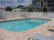 Sparkling community pool surrounded by a brick deck, lounge chairs and a white fence for privacy at 33821 Terrace Blvd, Wesley Chapel, FL 33543