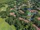Breathtaking aerial view capturing a tranquil pond, lush greenery, and a community pool amidst the neighborhood at 3476 Tarpon Woods Blvd, Palm Harbor, FL 34685