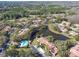 Scenic aerial view of the community featuring a pool, pond, and lush greenery at 3476 Tarpon Woods Blvd, Palm Harbor, FL 34685