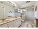 Bathroom featuring double sinks, a large mirror, a walk-in shower, and tiled floors at 3476 Tarpon Woods Blvd, Palm Harbor, FL 34685