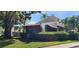 Exterior view of a home surrounded by green hedges, trees, and tropical palms at 3476 Tarpon Woods Blvd, Palm Harbor, FL 34685