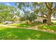 Charming home with lush front lawn, mature trees, and well-maintained landscaping at 3476 Tarpon Woods Blvd, Palm Harbor, FL 34685