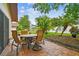 Relaxing brick paver patio with an outdoor dining set, and serene backyard views with lush landscaping at 3476 Tarpon Woods Blvd, Palm Harbor, FL 34685