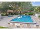 Community pool with lounge chairs, a jacuzzi, and surrounding trees at 3476 Tarpon Woods Blvd, Palm Harbor, FL 34685