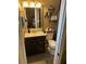 Bathroom featuring dark cabinets, a framed mirror, and a toilet with shelf for toiletries at 3612 Devonshire Dr, Holiday, FL 34691